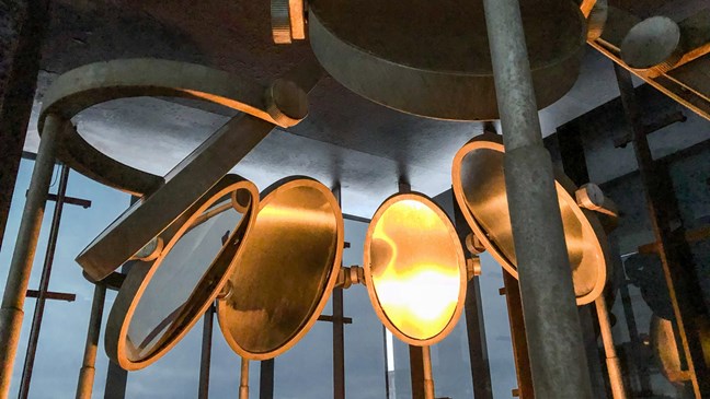 Das Kunstwerk von Louise Bourgeois besteht aus einem Stuhl mit fünf Gasflammen, die sich in sieben ovalen Spiegeln um den Stuhl spiegeln.