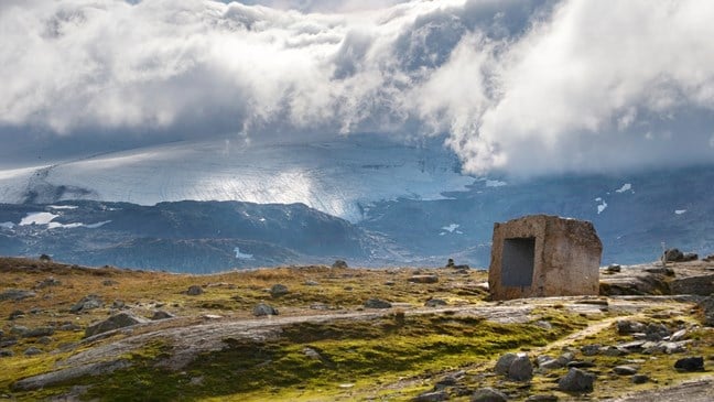 Die Steinskulptur am Rastplatz Mefjellet, Norwegische Landschaftsroute Sognefjellet, ist mittlerweile ein beliebtes Fotoobjekt, das von einer faszinierenden Bergwelt umgeben ist. Künstler: Knut Wold. 