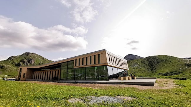 Large wooden building with a glass facade.