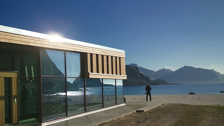 Nature is reflected in the glass facade of the building.
