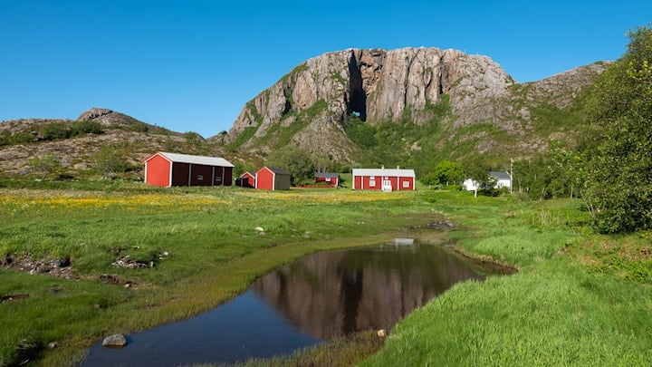 Et gårdsbruk i forkant av fjellet Torghatten.