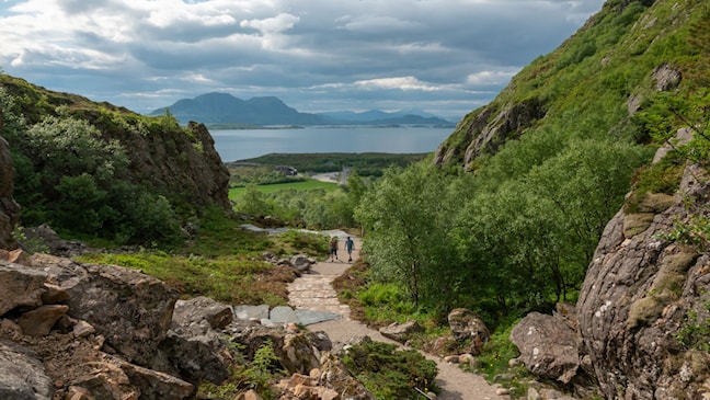 Turgåere på en sti oppover Torghatten.