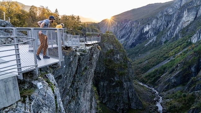 To menn ser over kanten på utsiktspunktet ved juvkanten.