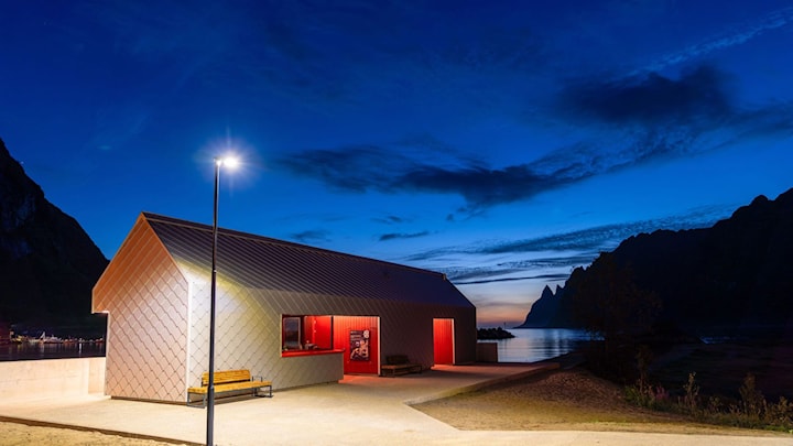 Det nye servicebygget er langstrakt, med en form hentet fra tradisjonelle sjøhus på Senja. Bygget ligger i strandkanten og har en sølvfarget kledning.