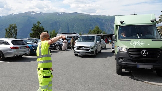 Trafikkvert i gul refleksvest dirigerer trafikken på Stegastein.