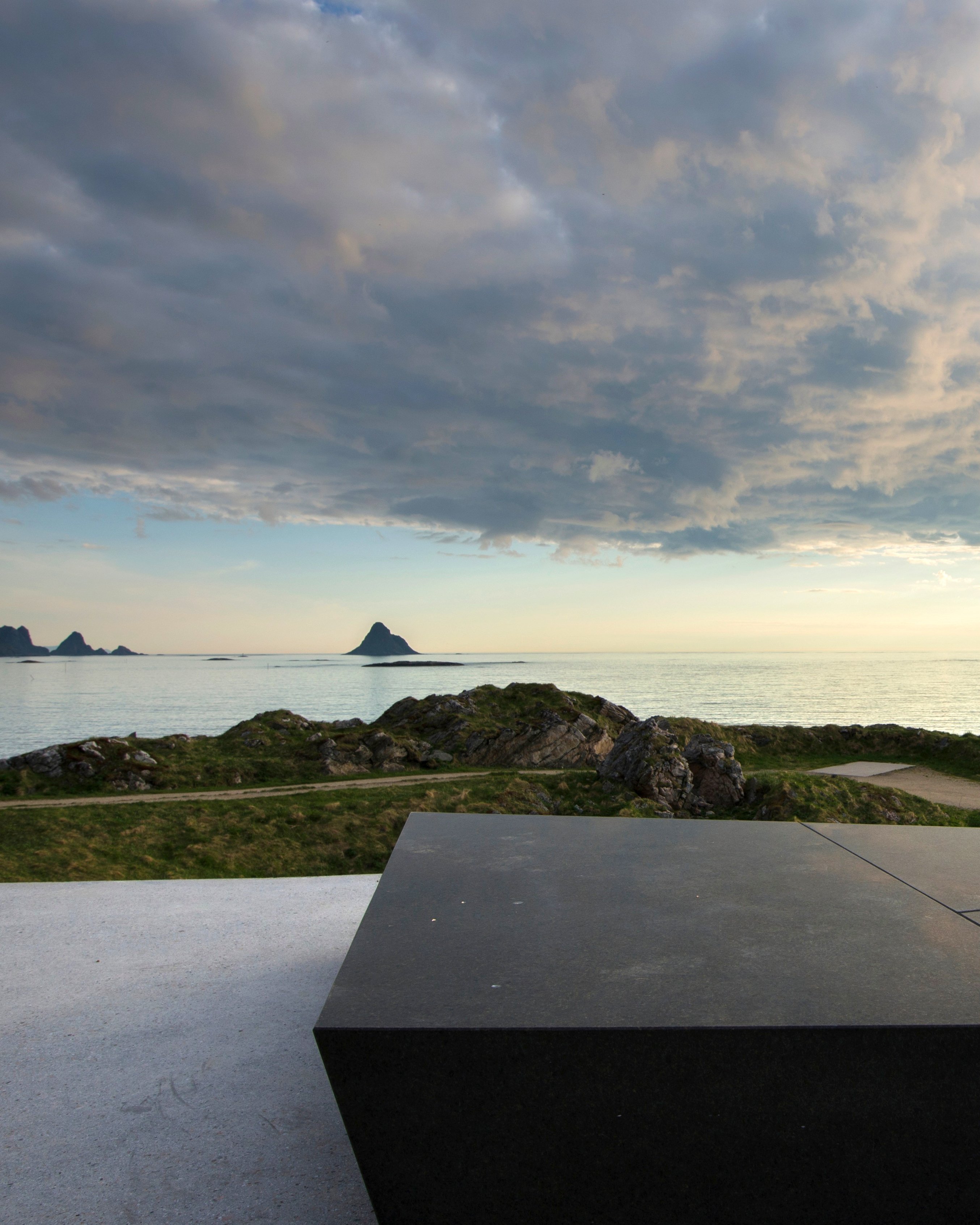Kleivodden rasteplass med utsyn mot havet, sola bryter gjennom skyene.