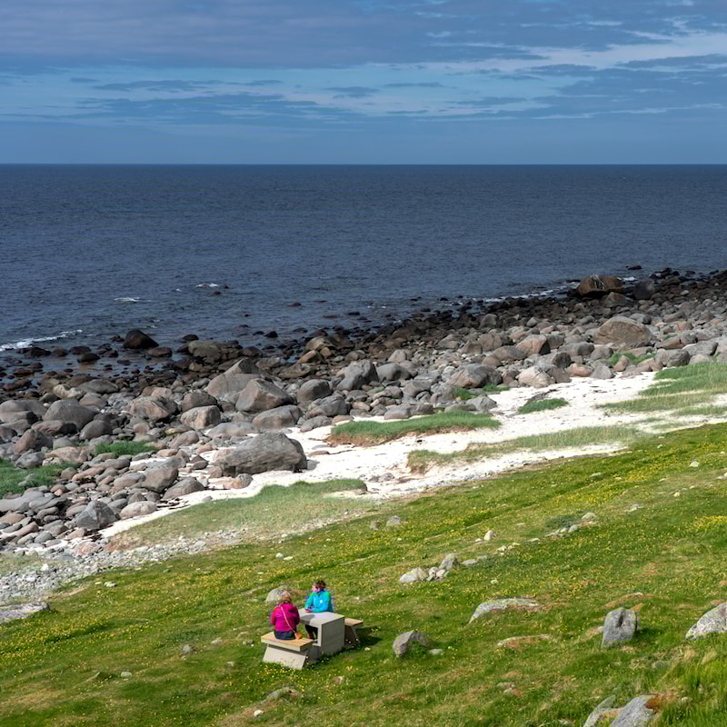 Zwei Frauen machen eine Pause am Strand.