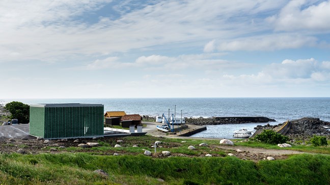 View of the harbour with toilet facilities and storm-watching cabin in front.